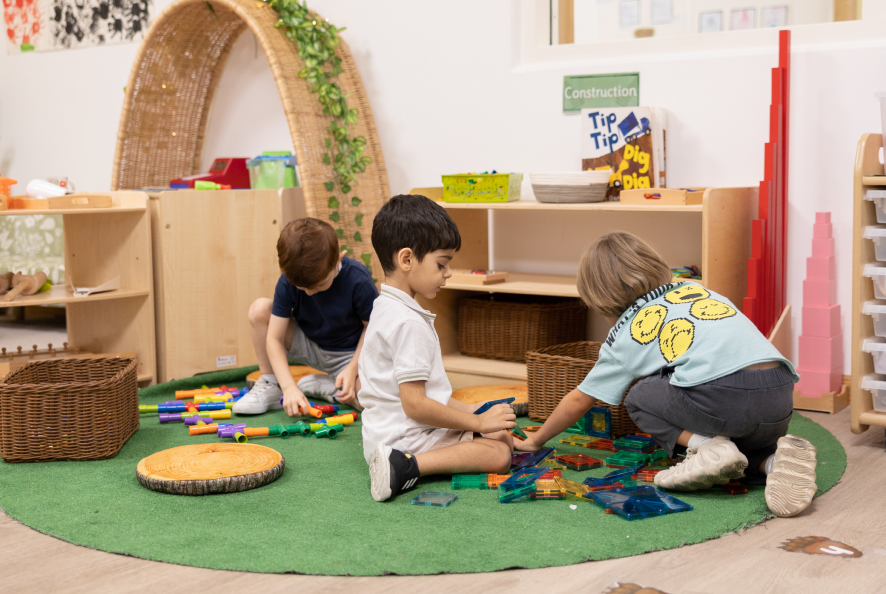 Three toddlers playing with toys on the room floor