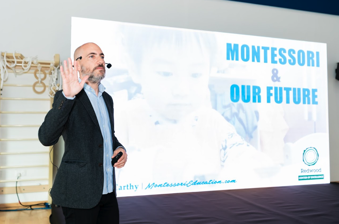 A man standing in front of a screen with the words montessori and our future.